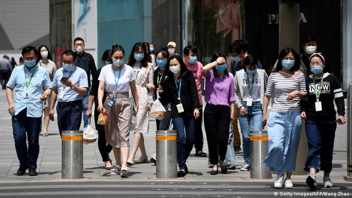 Transeuntes de máscara protetora em Pequim