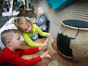 Boy and girl look at pottery