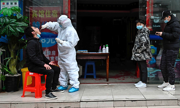 Nhân viên y tế mặc đồ bảo hộ lấy mẫu xét nghiệm nCoV cho dân tại thành phố Vũ Hán, Trung Quốc, ngày 29/3. Ảnh: AFP.