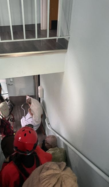 rescuers in a stairwell helping people down