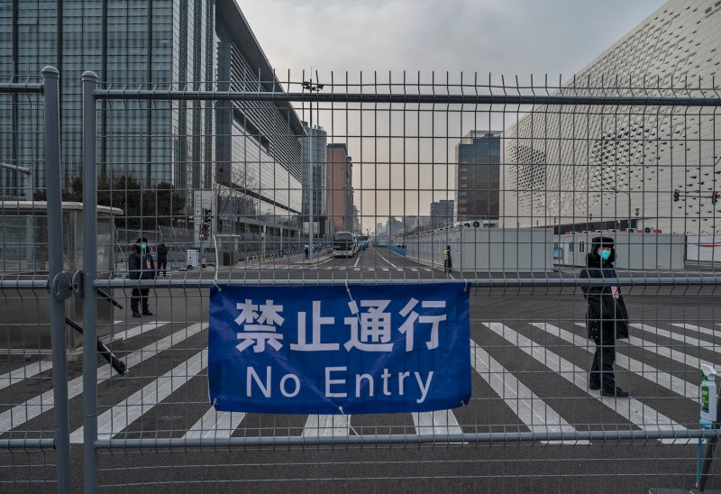 Security guards stand inside a fenced area  that is part of the closed loop bubble for people taking part in the 2022 Winter Olympics and Paralympics in Beijing on Jan. 19.