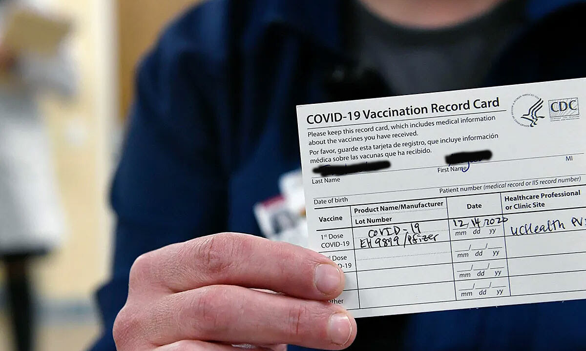 Một nhân viên y tế bệnh viện Bệnh viện Poudre Valley ở Colorado, Mỹ, cầm trên tay giấy chứng nhận tiêm chủng vaccine Pfizer. Ảnh: Denver Post.
