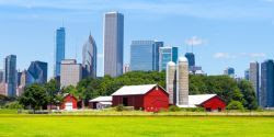 Photo of a farm in the foreground with a city skyline in the background