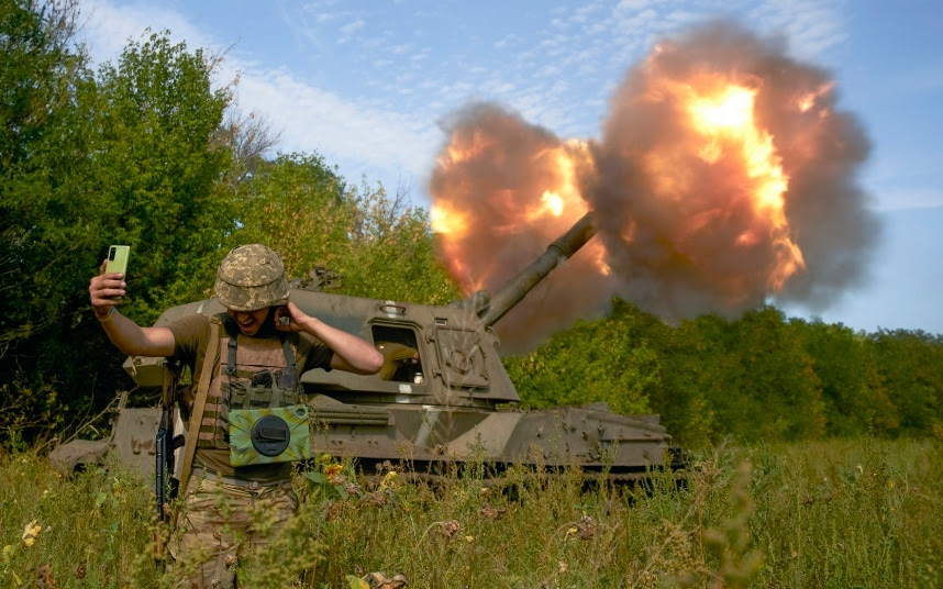 A Ukrainian soldier takes a selfie during artillery fire.