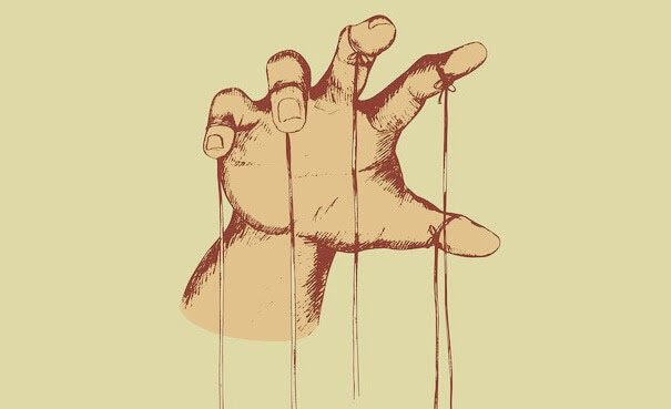 mano con hilos representando la representando las estrategias de manipulación masiva