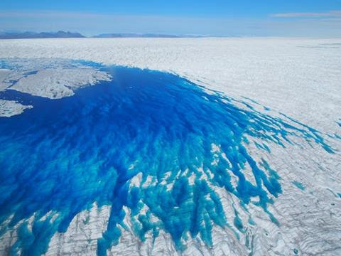 A blue meltwater lake on an ice sheet.