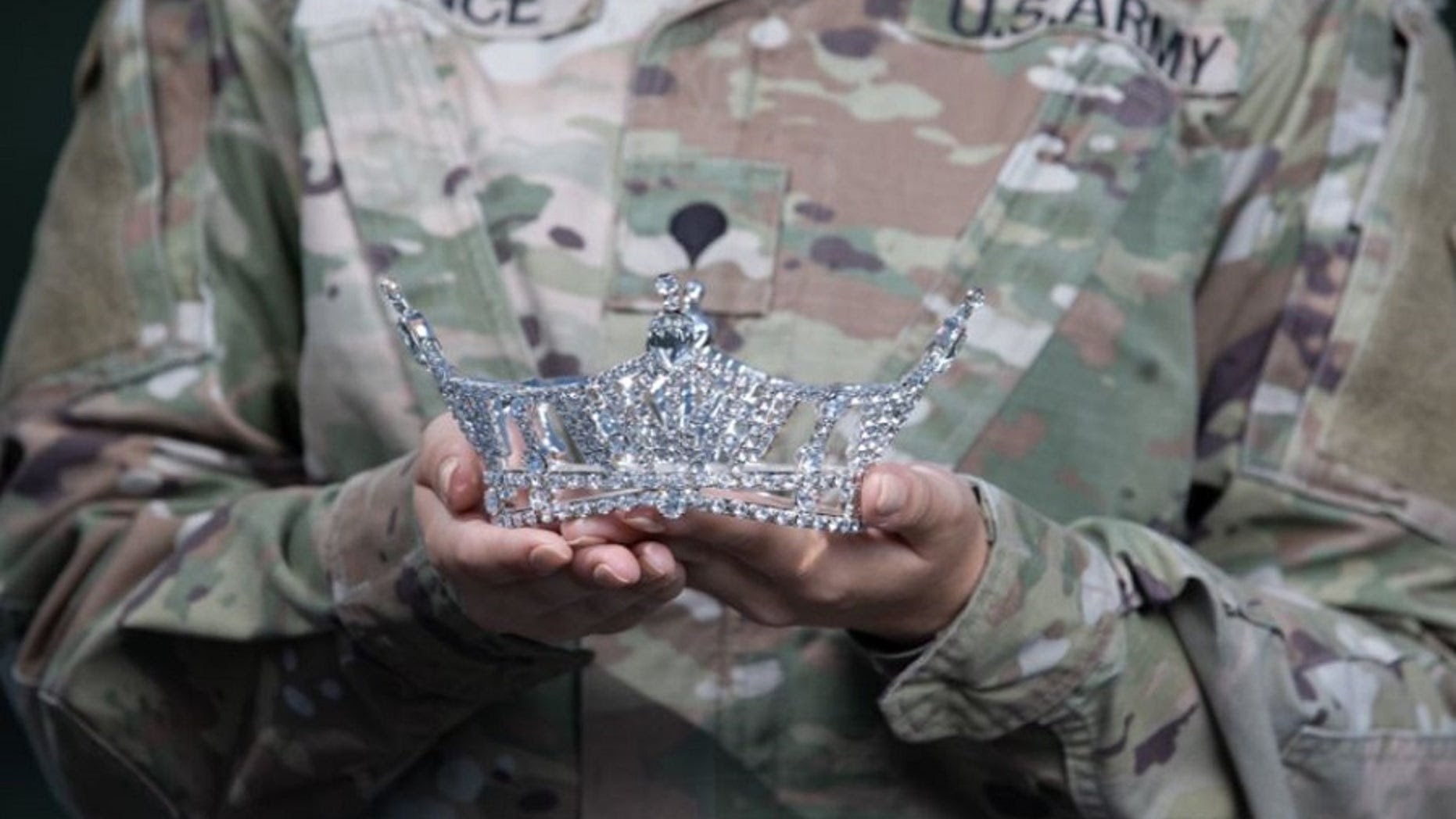 Army Spc. Maura Spence holds her crown