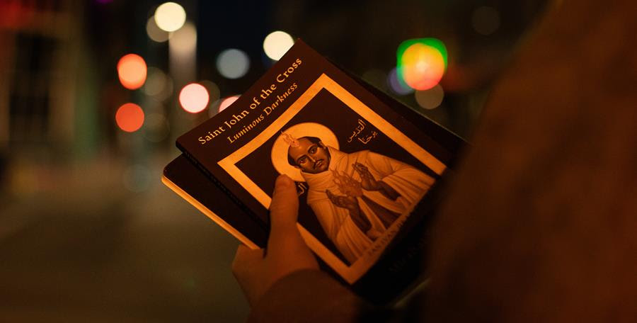 A photograph of someone holding the book Saint John of the Cross: Luminous Darkness