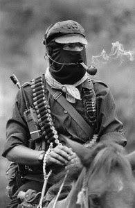 Subcomandante Marcos, the spokesman of the Ejército Zapatista de Liberación Nacional, smoking a pipe atop a horse in Chiapas, Mexico