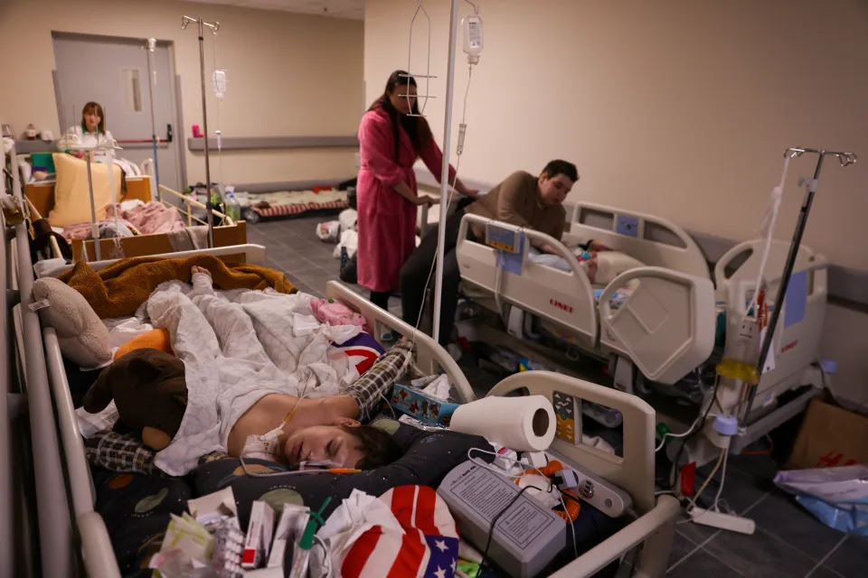 Young patients, in hospital beds, in the hallway of a children's hospital.