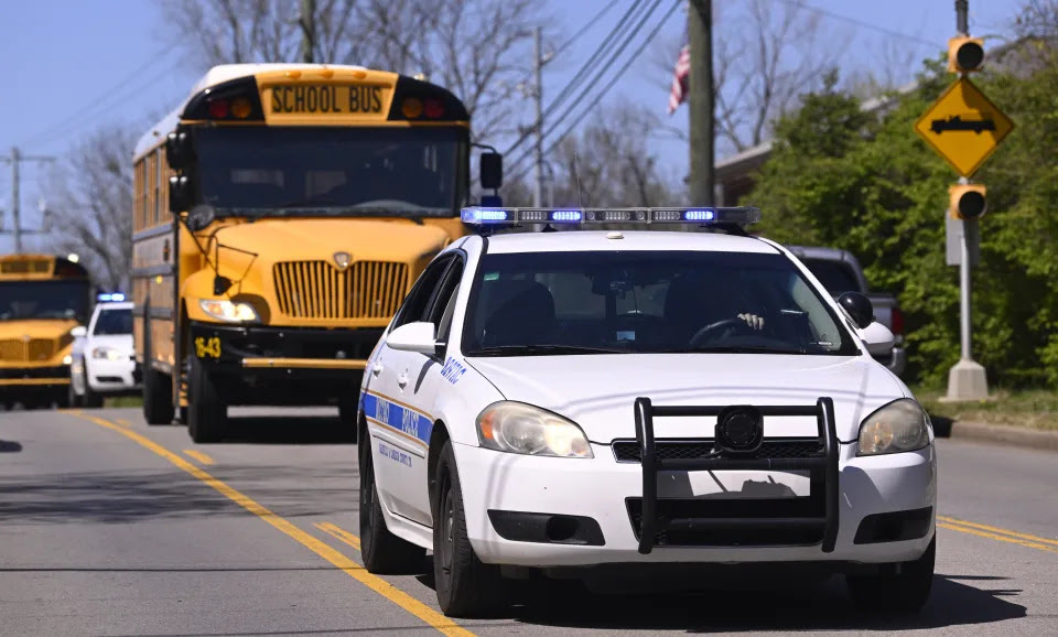 Metro Nashville Police cars escort evacuees from the school and church on schools buses as they leave Covenant School, Covenant Presbyterian Church, in Nashville, Tenn. Monday, March 27, 2023. Officials say several children were killed in a shooting at the private Christian grade school in Nashville. The suspect is dead after a confrontation with police. (AP Photo/John Amis)