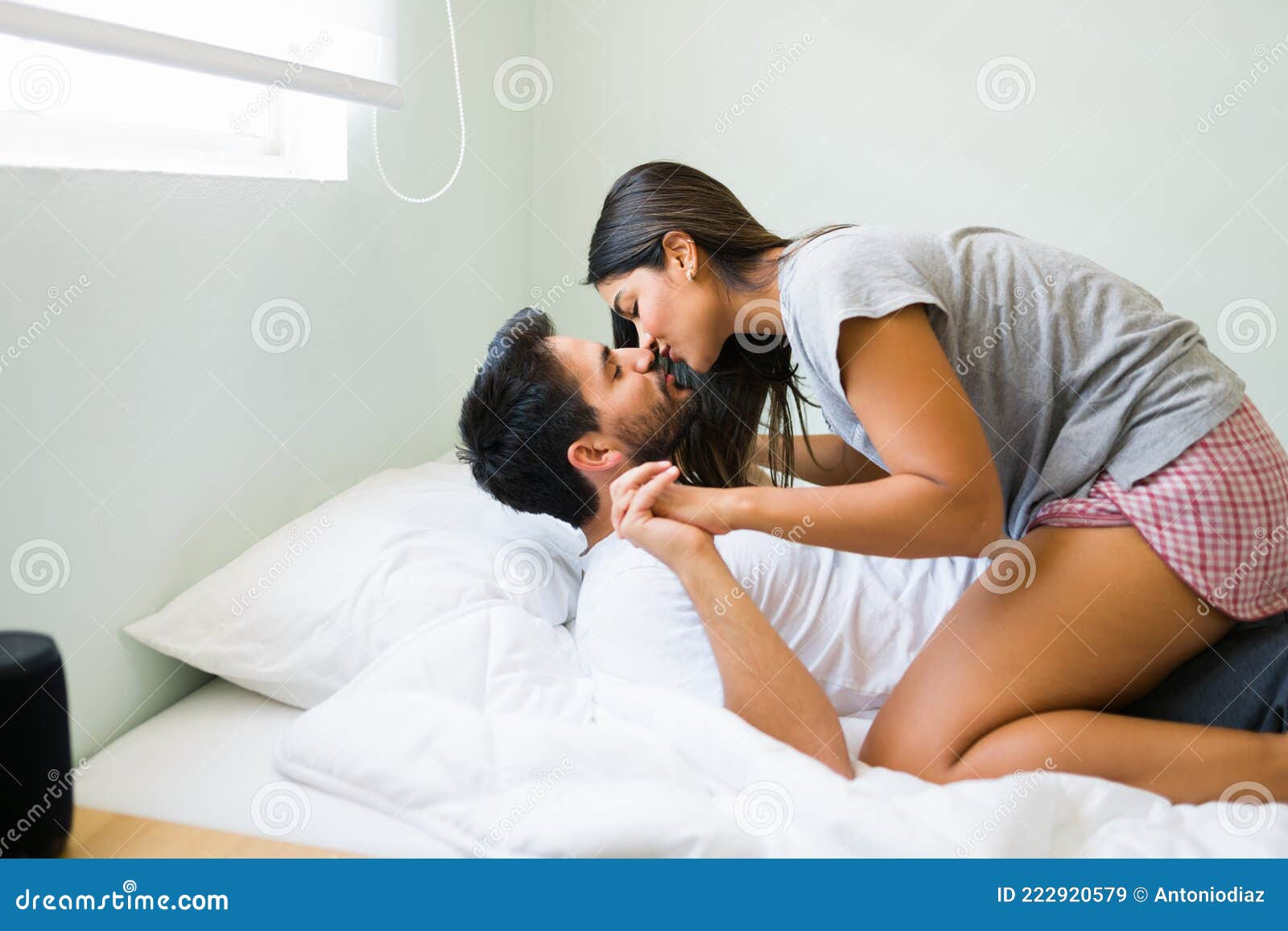 Seductive girlfriend kissing her partner in bed
