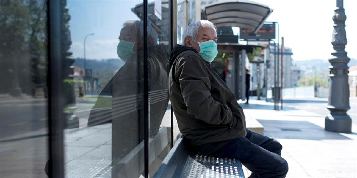 Un hombre con una mascarilla en una parada de autobús en Ourense.