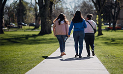 Three girls walking down Oval