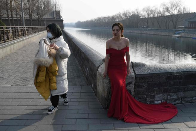 Una mujer lleva mascarilla durante una sesión de fotos en Pekín