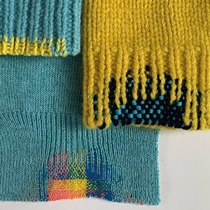 A photograph of three jumpers' cuffs which have been mended in colourful wools.