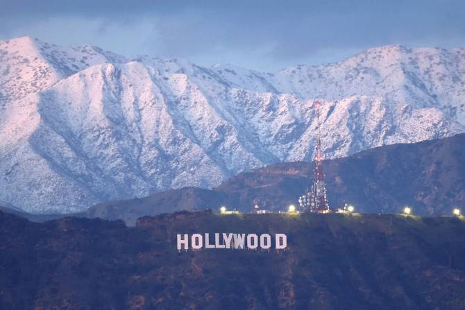 Hollywood sign in front of snow covered mountains.
