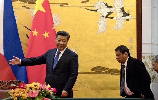 Duterte is shown the way by Chinese President Xi Jinping before a signing ceremony in Beijing in 2016. (Ng Han Guan/Associated Press)