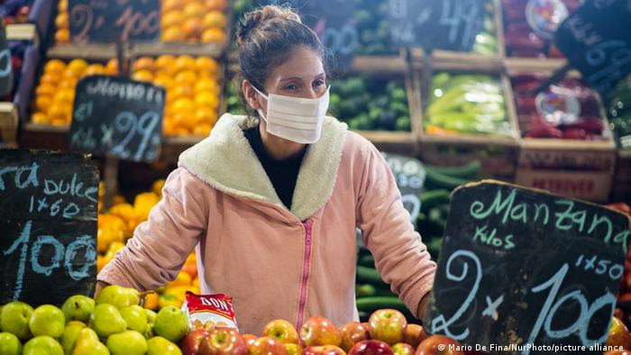 Mulher compra frutas em supermercado, com os preços à mostra.