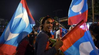 A supporter of Mr Mahathir celebrates in Kuala Lumpur on early 10 May 2018