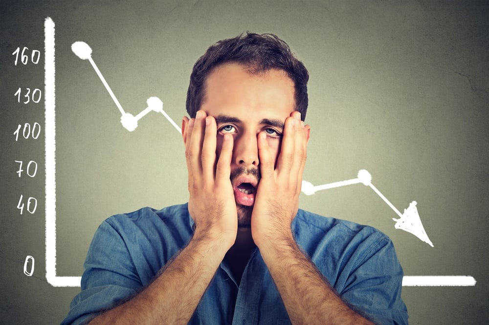 Msn with his face in his hands in front of a downward trending graph Msn with his face in his hands in front of a downward trending graph