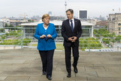 Secretary Blinken and Chancellor Merkel walking and talking side by side. 