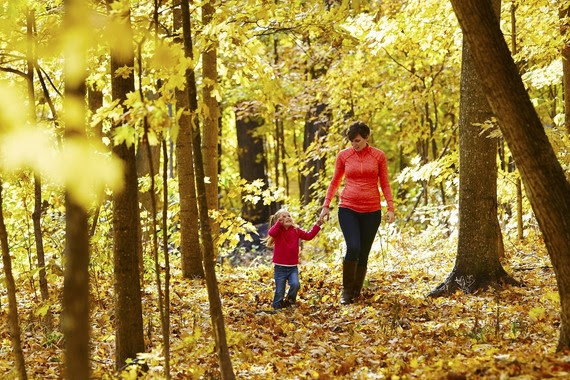 woman and girl walking in autumn woods