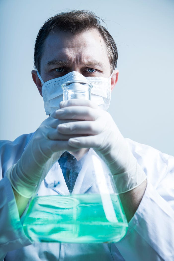 david sinclair in a mask, holding a beaker