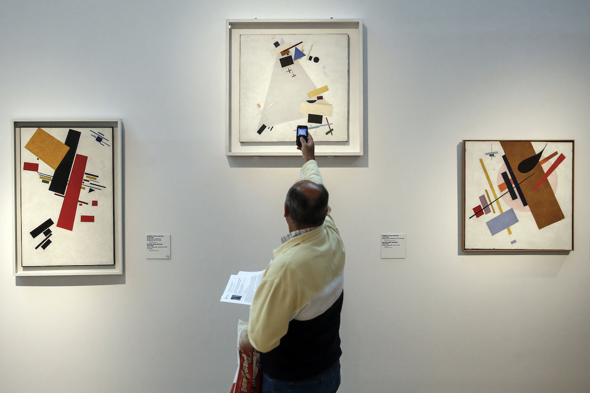 A picture taken on September 27, 2017 shows a visitor standing by Kazimir Malevich's artworks during the media preview of the exhibition titled "A certain 1917" at the Tretyakov Gallery.
From elegant portraits of aristocrats to scenes of protesters waving red flags, a major new exhibition of Russian art from 1917 that opened in Moscow on September 28, 2017 evokes the social turmoil of the revolutionary year. / AFP PHOTO / Maxim ZMEYEV / RESTRICTED TO EDITORIAL USE - MANDATORY MENTION OF THE ARTIST UPON PUBLICATION - TO ILLUSTRATE THE EVENT AS SPECIFIED IN THE CAPTION        (Photo credit should read MAXIM ZMEYEV/AFP via Getty Images)