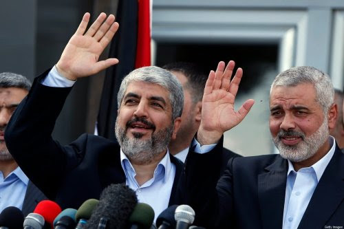 Hamas leaders Khaled Meshaal (L) and Ismail Haniya (R) wave during a press conference following Meshaal's arrival in Rafah, southern Gaza, on December 7, 2012 [SUHAIB SALEM/AFP via Getty Images]