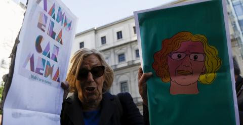 Manuela Carmena sostiene dos carteles sobre su candidatura, durante la campaña electoral. REUTERS/Sergio Perez
