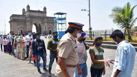  People queue up as they wait for their turn to undergo a mandatory COVID-19 test before entering the Gateway of India in Mumbai. 