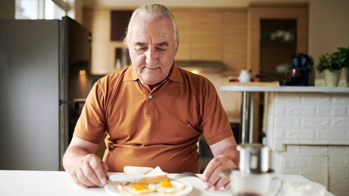A man is preparing to eat breakfast at home.