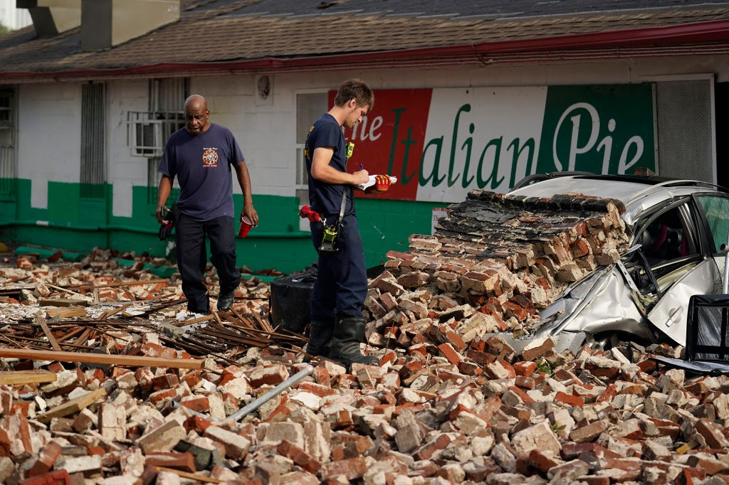 New Orleans Firefighters assess damages as they look through debris after a building collapsed from the effects of Hurricane Ida.
