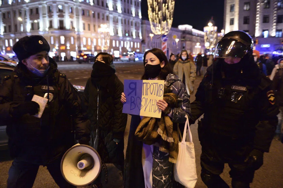 Police officers detain a demonstrator with a poster that reads: I'm against the war, in Moscow, Russia, Thursday, Feb. 24, 2022, after Russia's attack on Ukraine. Hundreds of people gathered in the center of Moscow on Thursday, protesting against Russia's attack on Ukraine. Many of the demonstrators were detained. Similar protests took place in other Russian cities, and activists were also arrested. (AP Photo/Denis Kaminev)