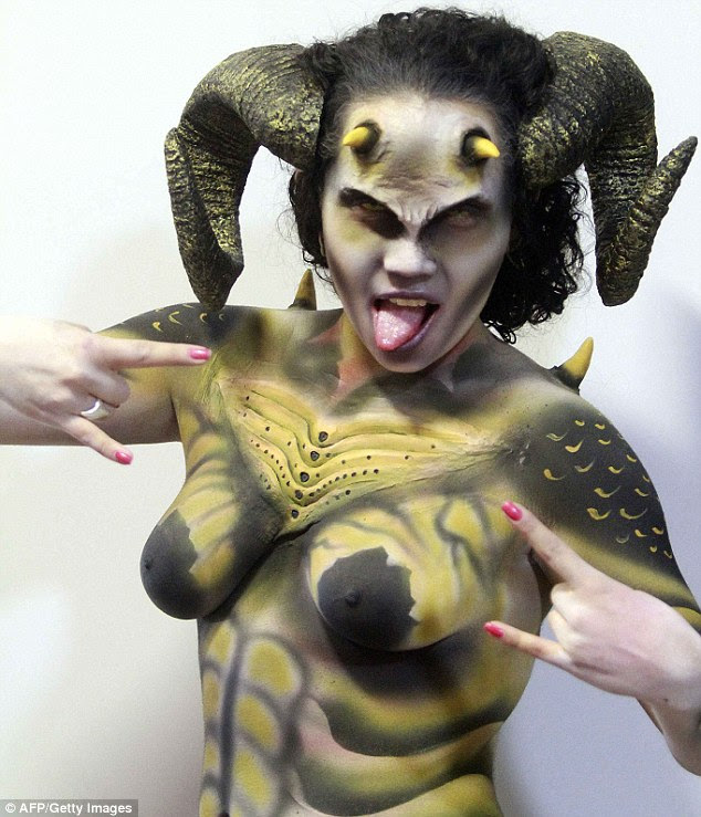 Painted lady: A woman who has had her entire body tattooed shows off her extreme appearance - including devil horns