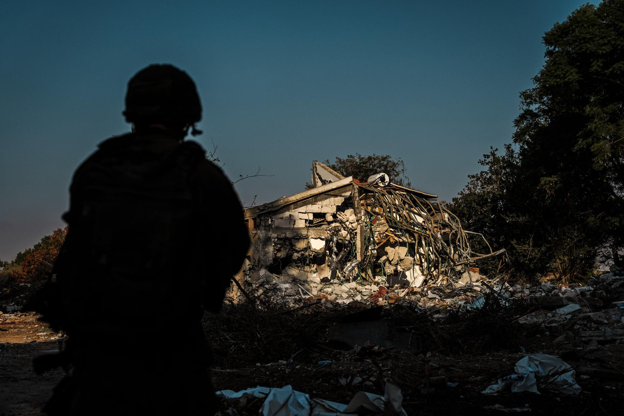 Las fuerzas israelíes se encuentran cerca de los escombros vistos en el Kibbutz en Be'eri, Israel.