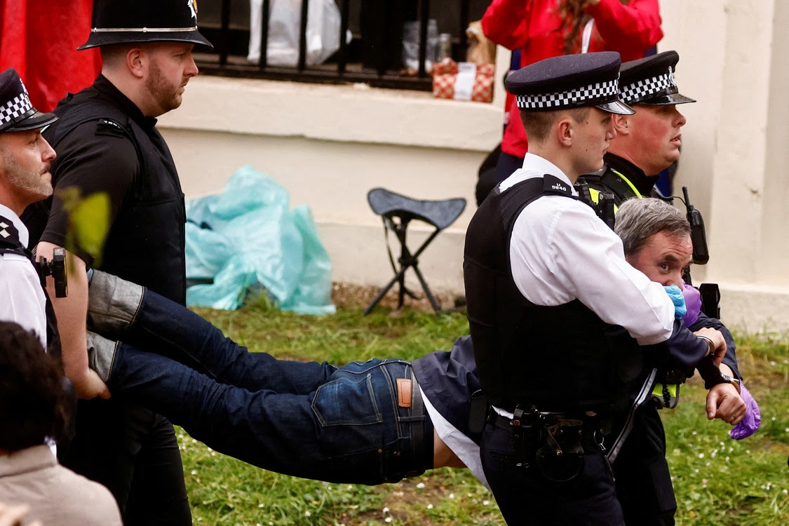Các sĩ quan cảnh sát bắt giữ một thành viên của phong trào Just Stop Oil trong một cuộc biểu tình trước đám rước của Vua Charles của Anh.  REUTERS/Yara Nardi/Bể bơi