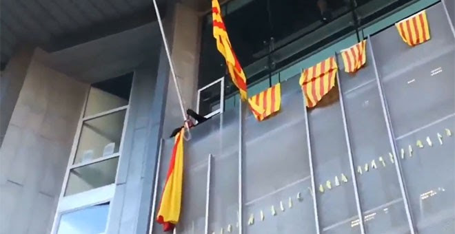 Momento en el que un grupo de los CDR retira la bandera española en la Delegación de la Generalitat en Girona