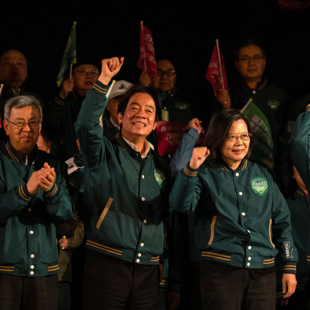 Lai Ching-te y Tsai Ing-wen en el escenario de un mitin político levantando los puños y sonriendo