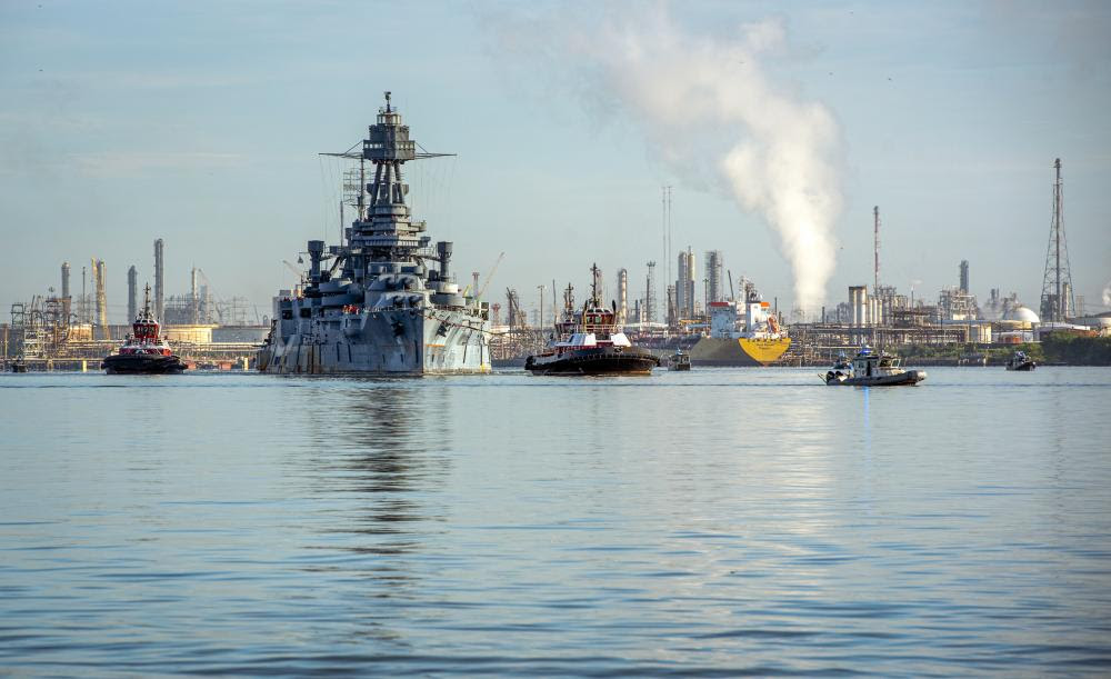 Law enforcement boat crews protect the battleship USS Texas as pilot boat crews tow the historic ship down the Houston Ship Channel near Baytown, Texas, Aug. 31, 2022. The USS Texas is moving from the San Jacinto Battleground State Historic Site in La Porte, Texas, to a dry dock in Galveston, Texas, where it will undergo extensive hull repairs. (U.S. Coast Guard photo by Petty Officer 1st Class Corinne Zilnicki)