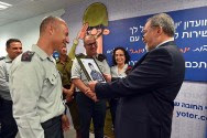 Defense Minister Liberman looking at his own 1979 recruit's photo at the IDF reception and screening center. / Facebook