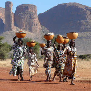 Imagen finalista de mujeres de la tribu peul, en Malí, con grandes cuencos de ropa y leche sobre sus cabezas.