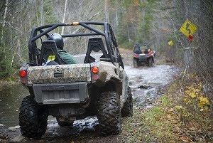 Rear view of an ORV on a muddy trail, with another ORV up ahead