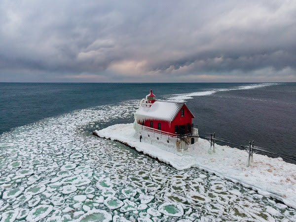 aerial view of the iced-in pier around the Grand Haven Lighthouse