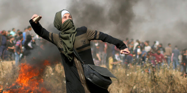 Girl hurls stones during clashes with Israeli troops at a protest where Palestinians demand the right to return to their homeland, at the Israel-Gaza border, east of Gaza City
