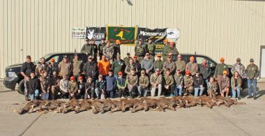 ECOs and large group of youth hunters take photo with the deer they hunted during event
