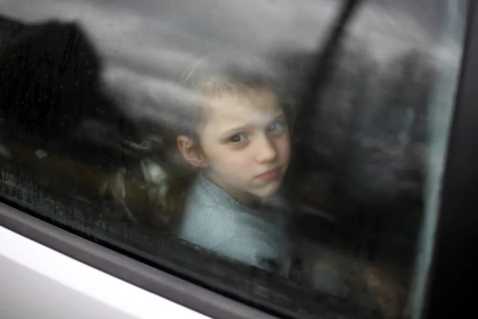 A Ukrainian child in a car stuck in traffic.